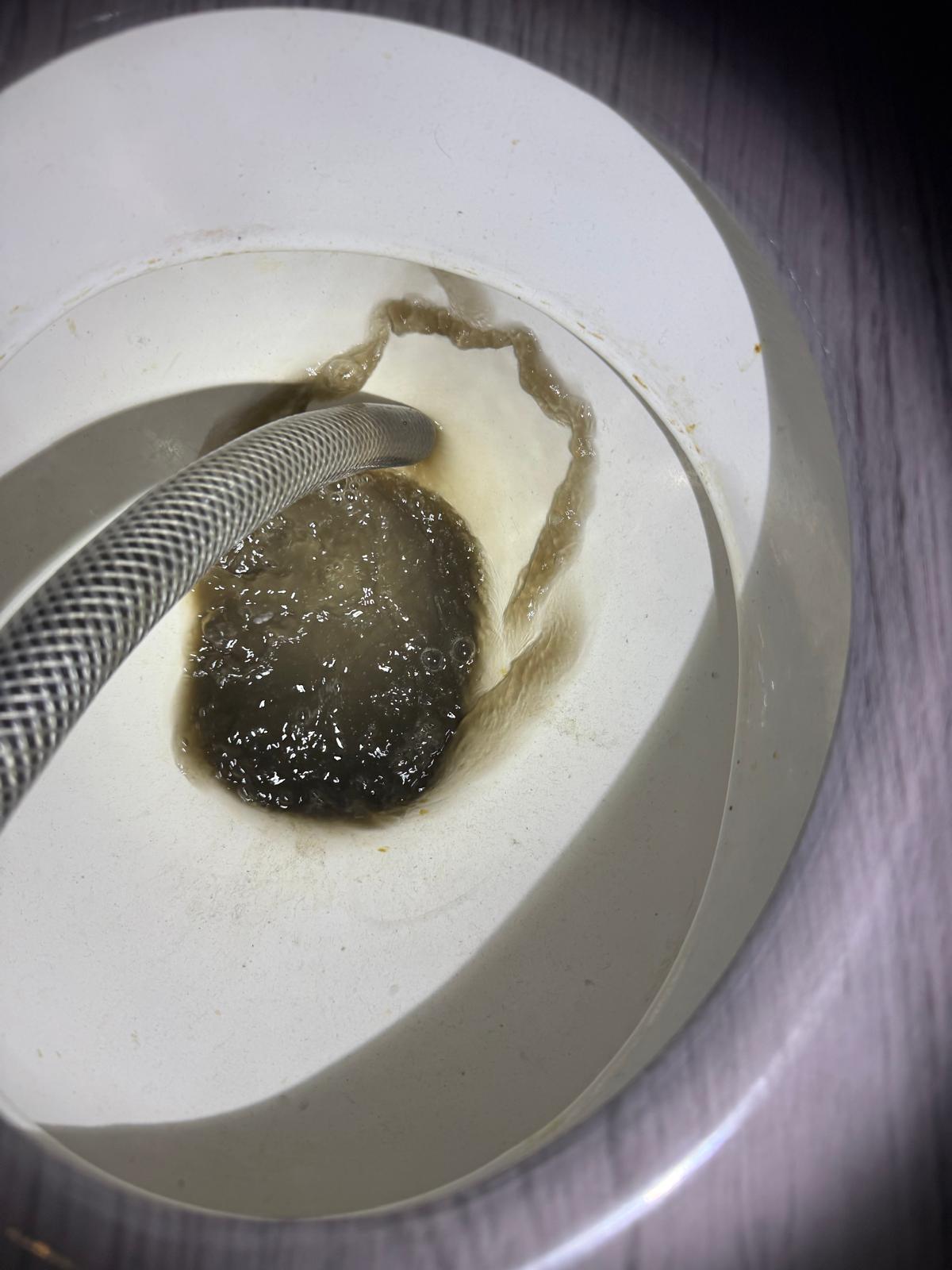 Dirty heating system water sample taken before power flushing